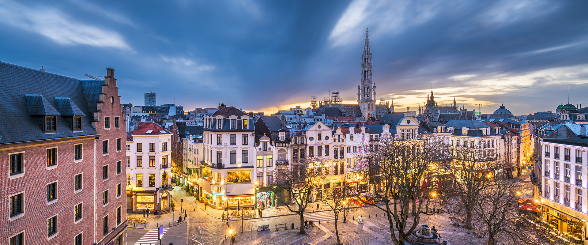 Brussels, Belgium plaza and skyline with the Town Hall tower at dusk.