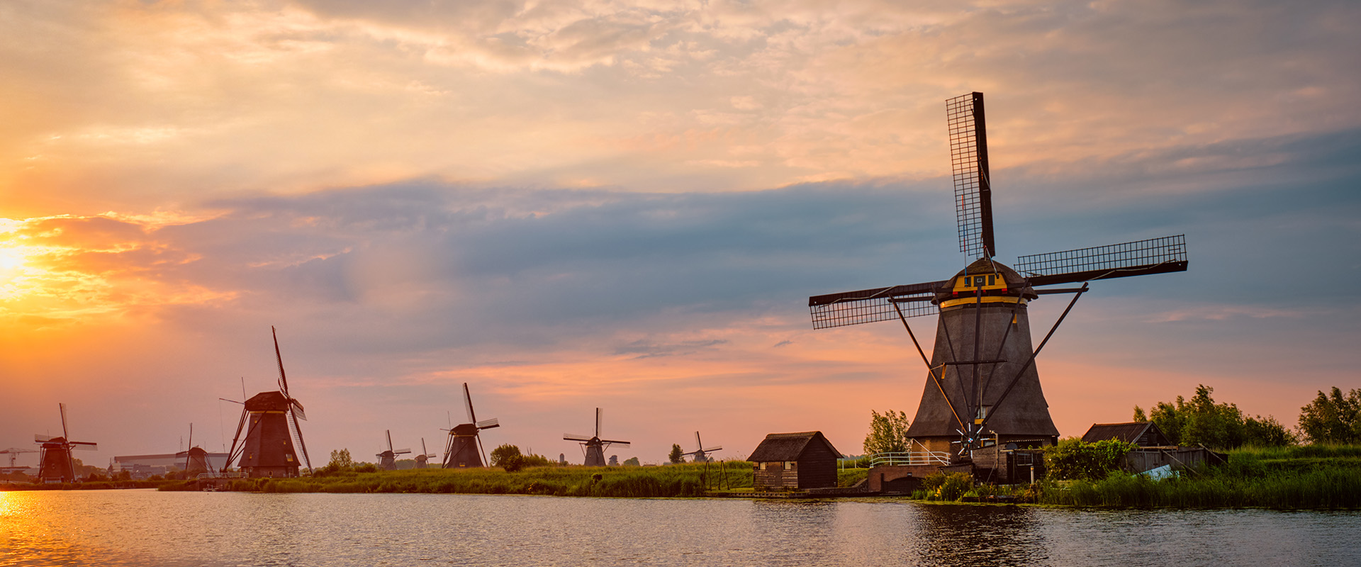 Netherlands rural landscape with windmills at famous tourist site Kinderdijk in Holland on sunset with dramatic sky